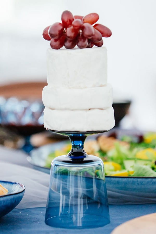 Cheese topped with grapes on upturned blue glass