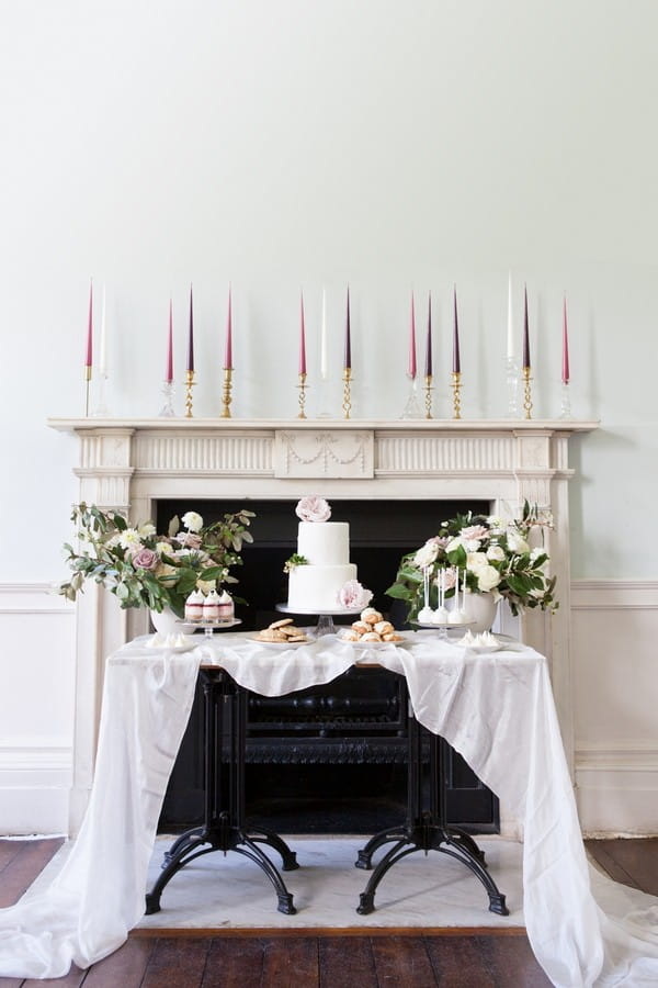 Wedding dessert table in front of mantelpiece at Clissold House