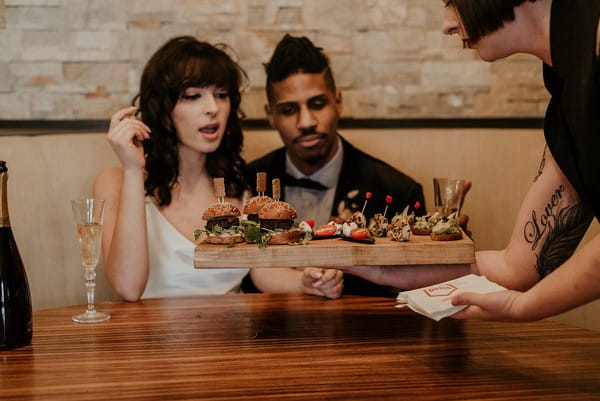 Bride and groom being served burger sliders