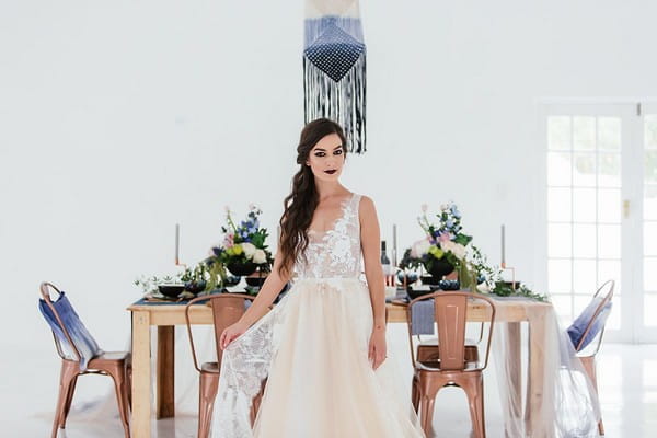 Bride standing in front of wedding table