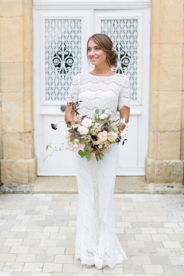 Bride in two piece wedding dress holding bouquet