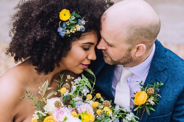 Bride with flowers in her hair sharing intimate moment with groom in blue suit - Picture by Berni Palumbo Photography