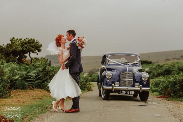 Bride and groom standing in road by classic wedding car - Picture by Special Day Wedding Photos