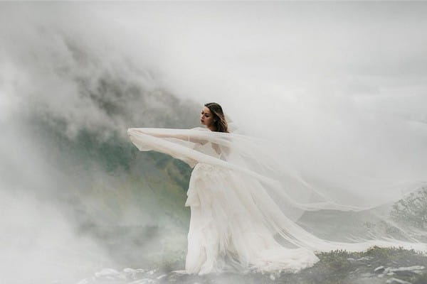 Dramatic picture of bride surrounded by mist in mountains - Picture by Relic Photographic