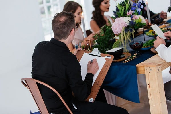 Caricaturist sitting at wedding table drawing guests