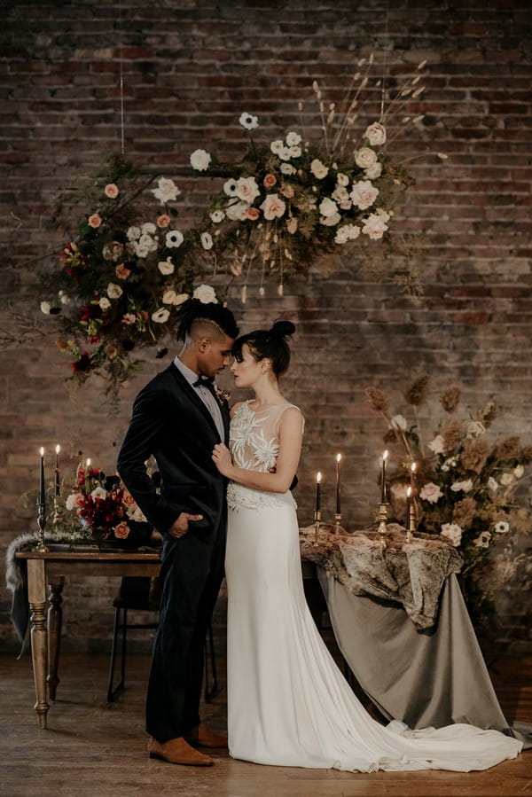 Bride and groom touching heads in front of autumn styled wedding table