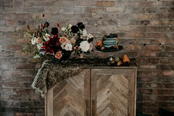 Wedding cake table decorated with fur and autumn flowers