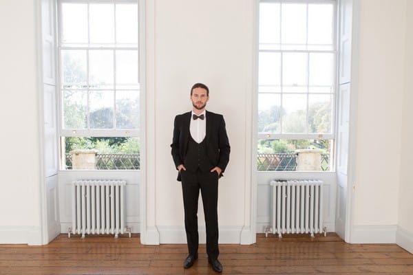 Groom wearing black suit and bow tie in Clissold House