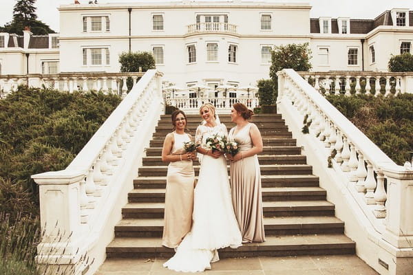 Bride and bridesmaids on steps at Coworth Park