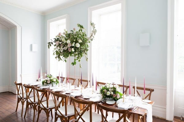 Long wedding table with wooden chairs in dining room at Clissold House