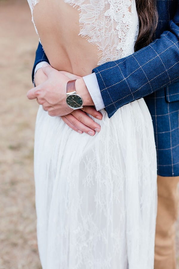 Groom's arms around bride's waist