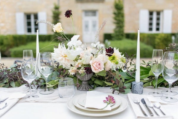 Wedding table flowers in front of place setting