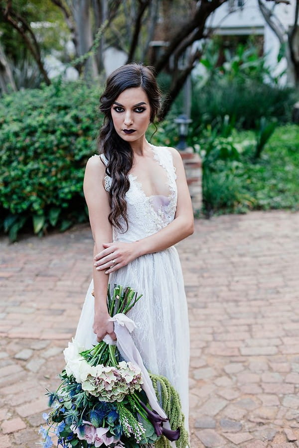 Bride with dark make-up holding large winter wedding bouquet