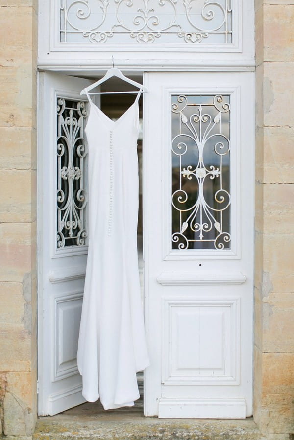 Wedding dress hanging in doorway at Chateau de Redon