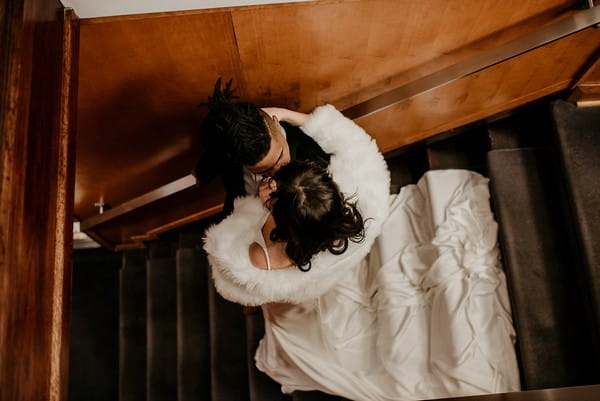 Bride and groom kissing on stairs