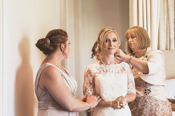 Bride getting ready for wedding with mother and bridesmaids