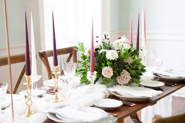 Coloured candles and flowers on wedding table