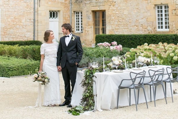 Bride and groom standing by table with organic wedding styling