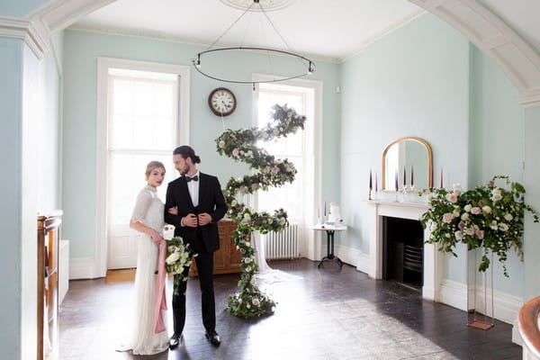 Bride and groom in Clissold House next to spiral floral feature