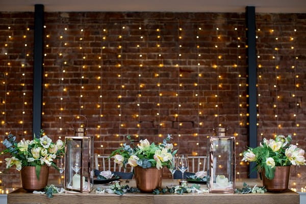 Foliage and copper wedding styling on wooden table