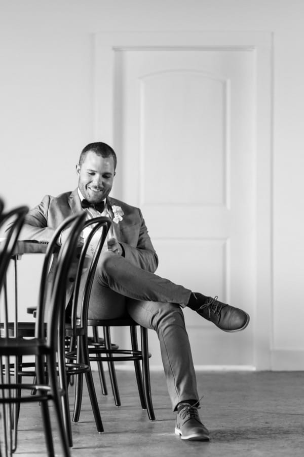 Groom sitting reading note from bride