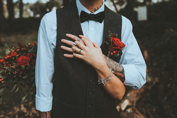 Groom holding bride's hand against his chest