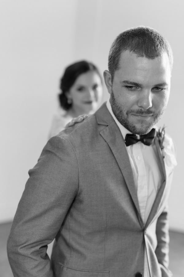 Groom about to turn and see bride