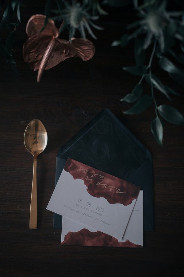 Dark stationery and gold cutlery for industrial wedding