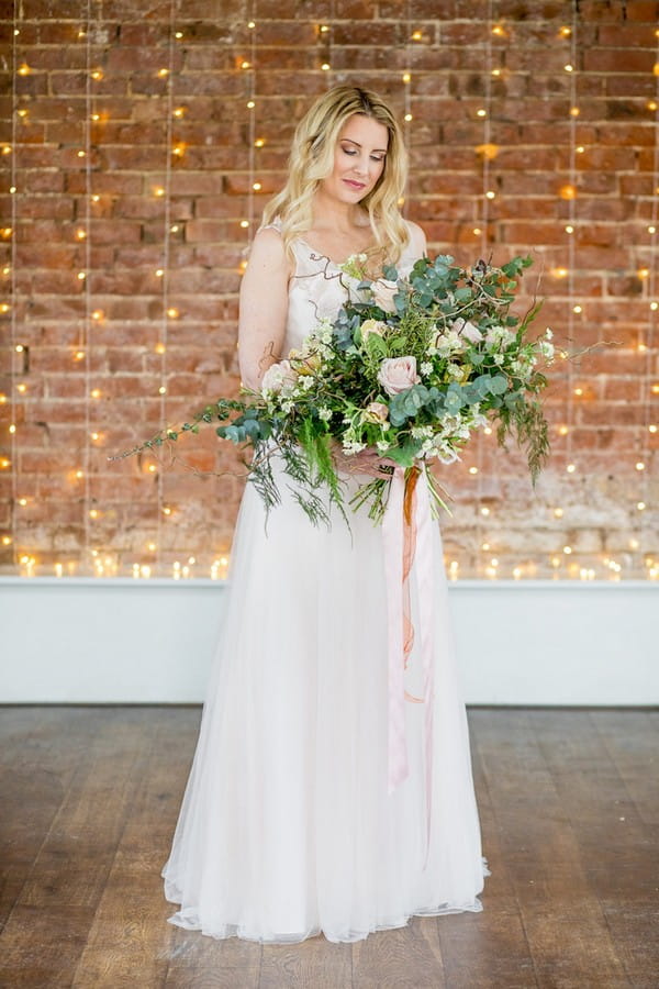 Bride holding wild oversized foliage bouquet