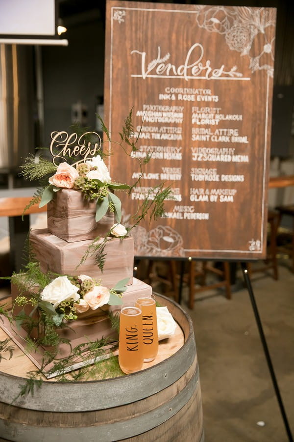 Wedding cake on barrel in front of vendor sign