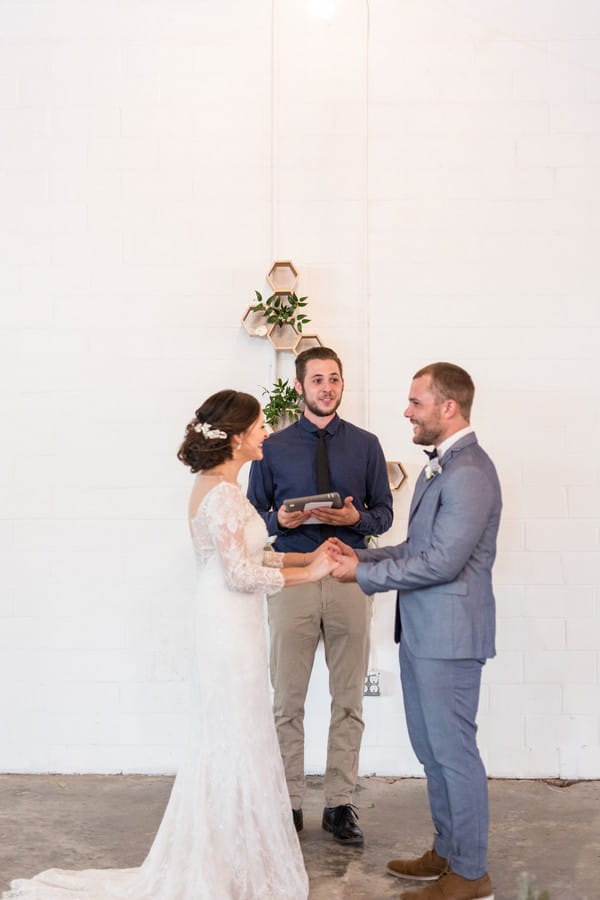 Bride and groom holding hands as celebrant conducts wedding ceremony at East Crossing