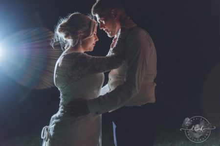 Bride and groom lit up by light at night - Picture by Life Through A Lens - Rachel Ellis Photography