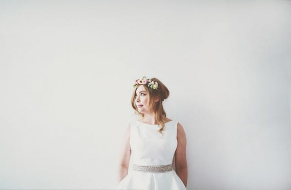 Bride standing up against white wall - Picture by On Love and Photography