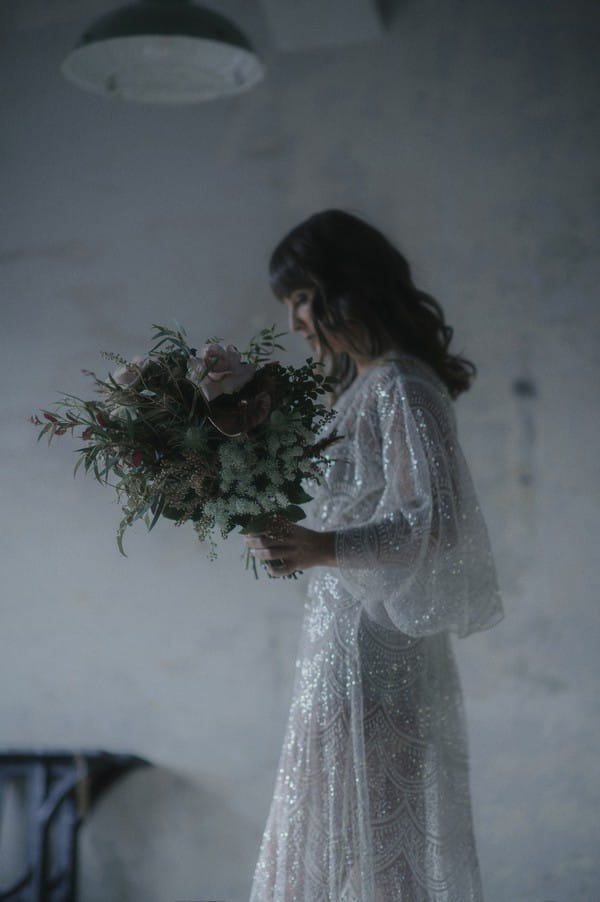 Bride carrying bouquet in warehouse