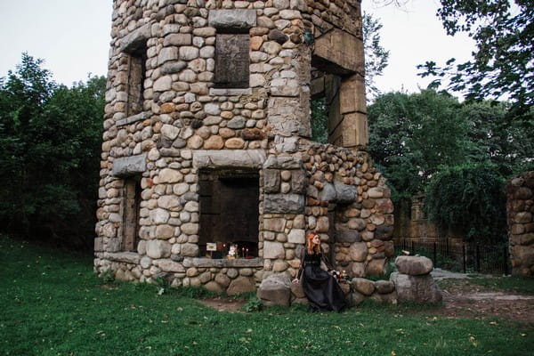 Bride sitting on rocks outside castle