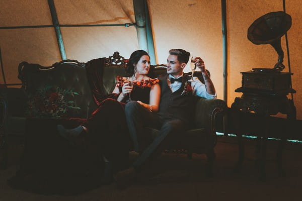 Bride and groom sitting on couch in tipi