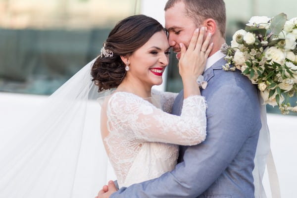 Bride with hands on groom's face