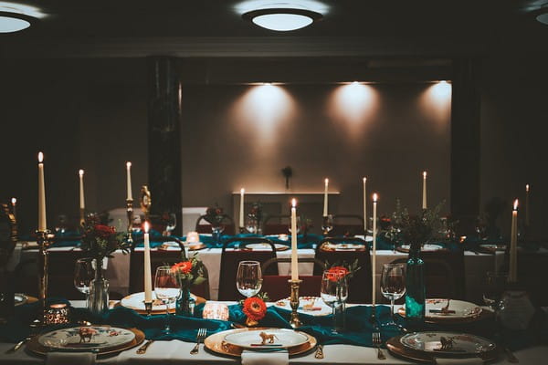Wedding tables dressed with teal runners and candles