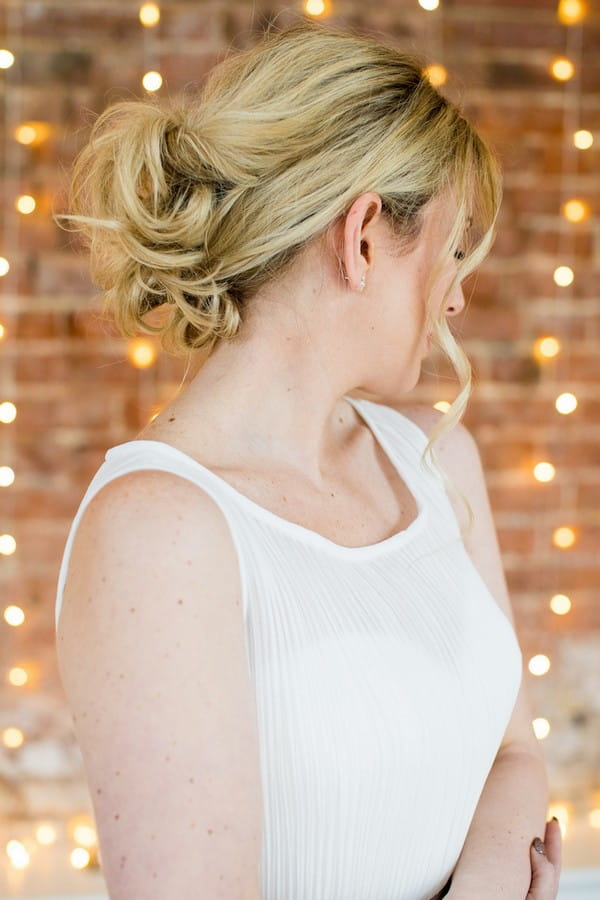 Bride showing back of messy updo hairstyle