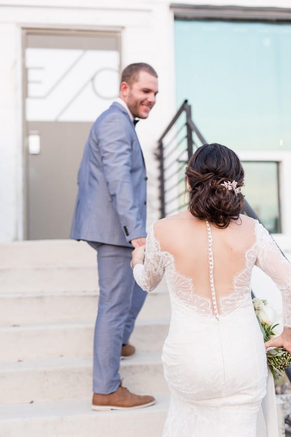 Groom leading bride up steps of East Crossing