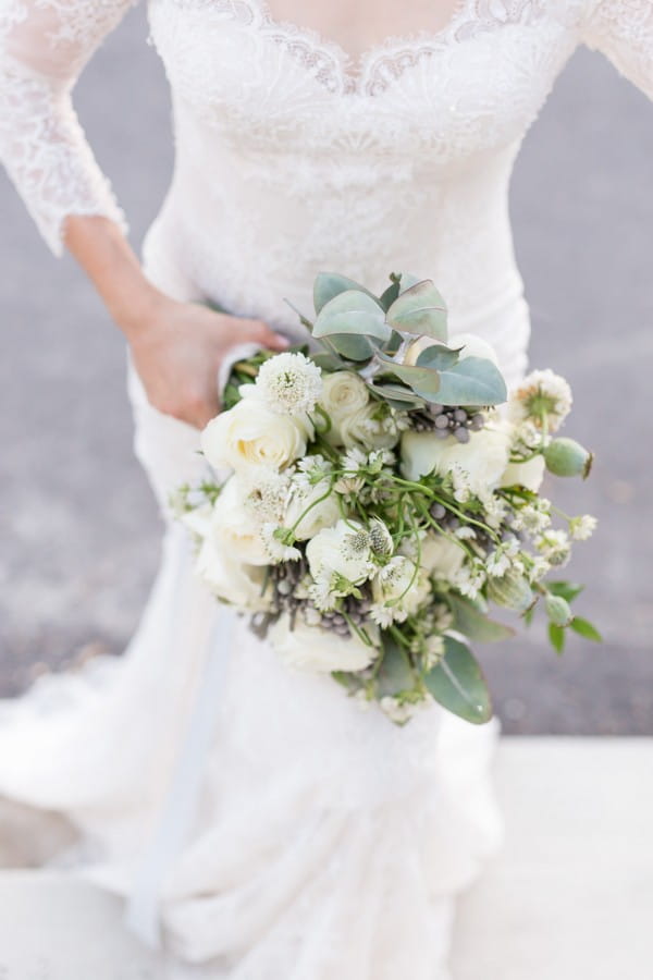 Bride carrying white and green wedding bouquet