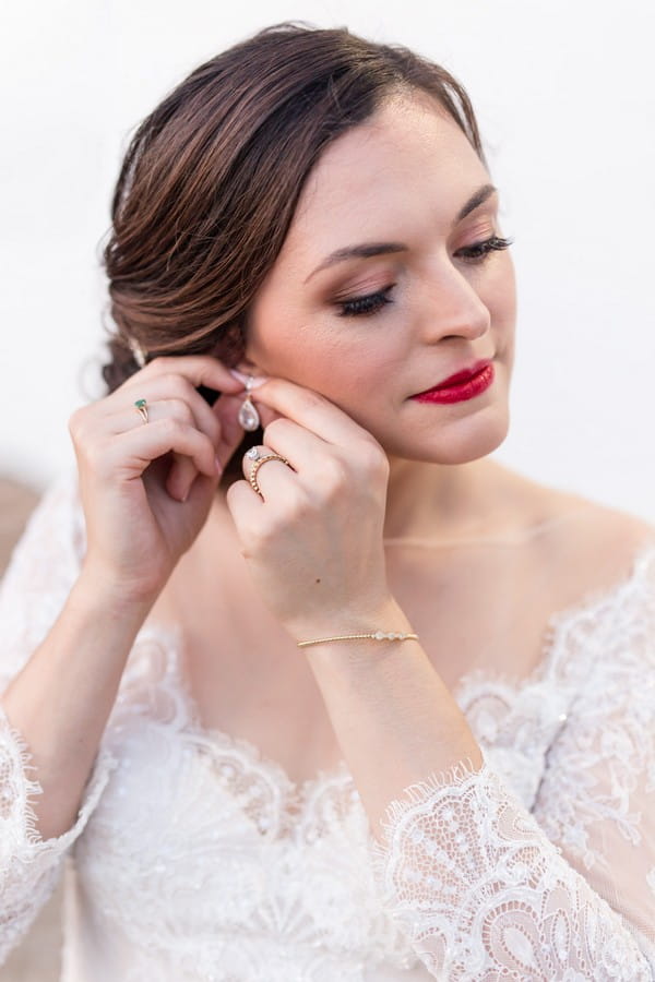 Bride putting on earring