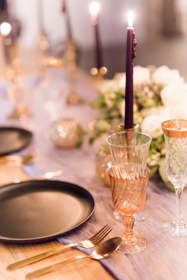 Glassware and purple candles on wedding table