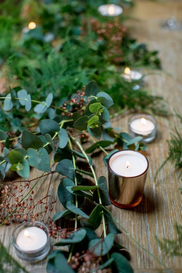 Foliage and copper votives on wedding table