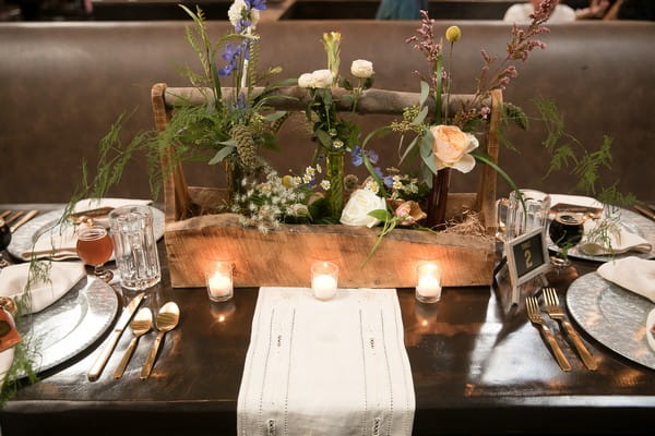 Wooden planter of wedding flowers in centre of table