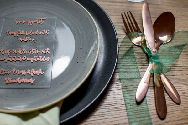 Copper cutlery wrapped in green ribbon