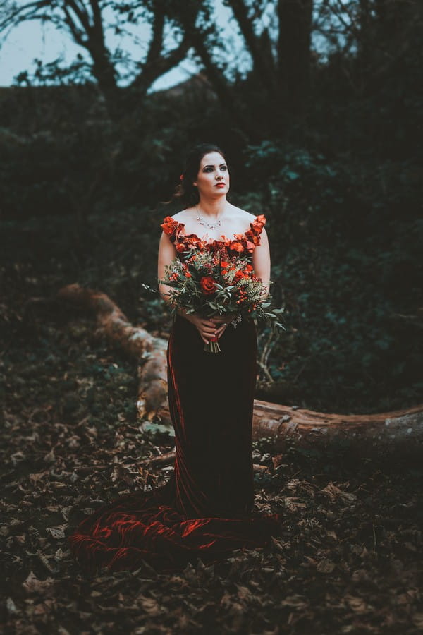Bride with red wedding dress holding red bridal bouquet