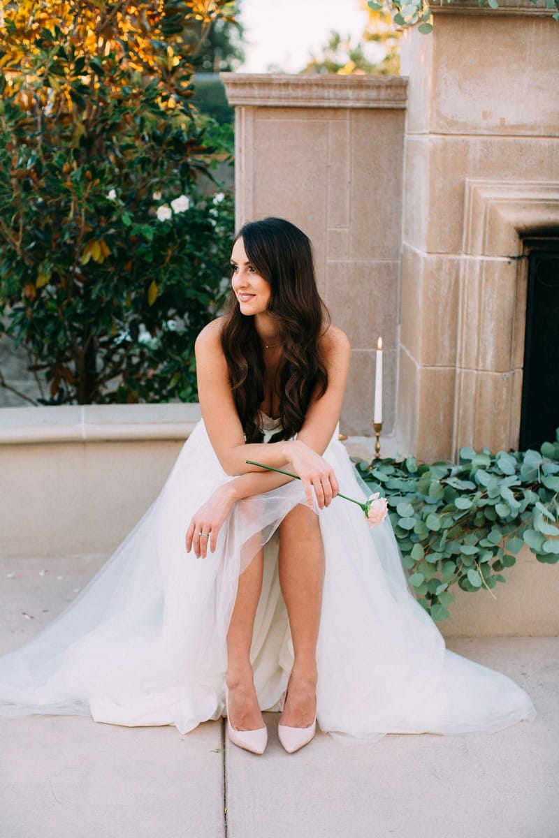 Bride sitting next door to outdoor fireplace