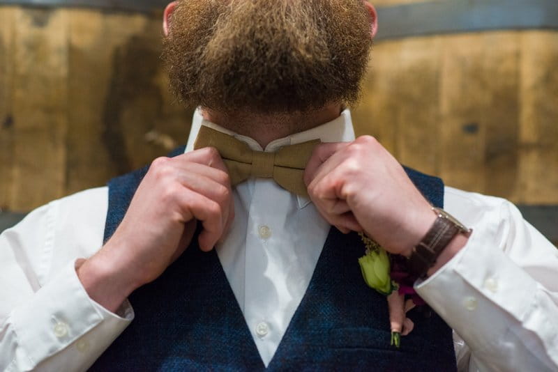 Groom adjusting bow tie