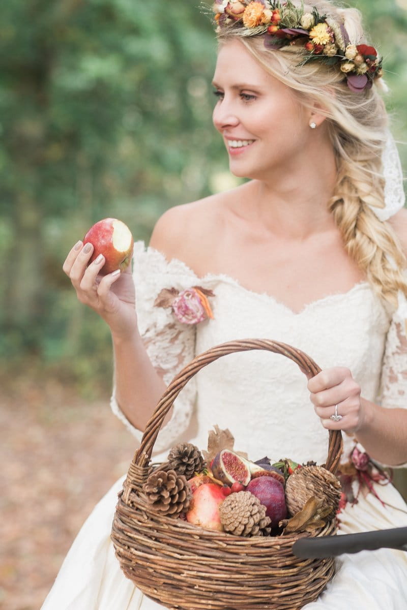 Bride holding apple and basket of fruit